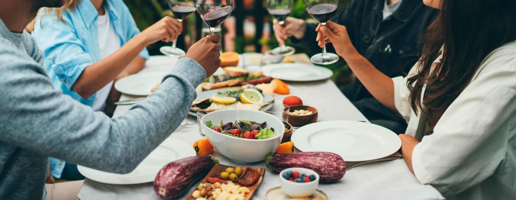 a group of people having a meal around an outdoor table